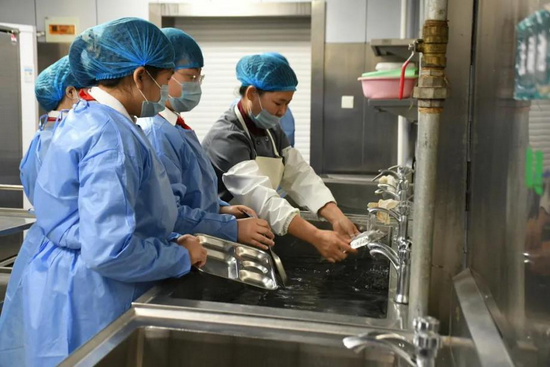 学生们学习如何给餐具清洗和消毒