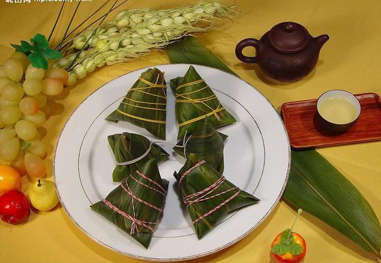 [端午食粽：粽子，又名“角黍”、“筒粽”。其由来已久，花样繁多。晋代，被正式定为端午节食品。]
