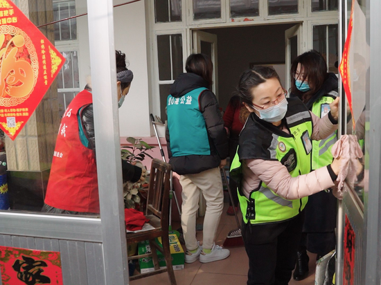 莱西市望城街道的工作人员和新时代文明实践站的志愿者们为老人卫生大扫除