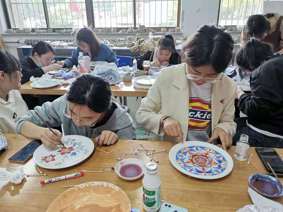 《陶艺制作》课上学生在手绘彩瓷