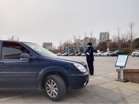 (工作人员引导企业车辆往专属车位停泊)