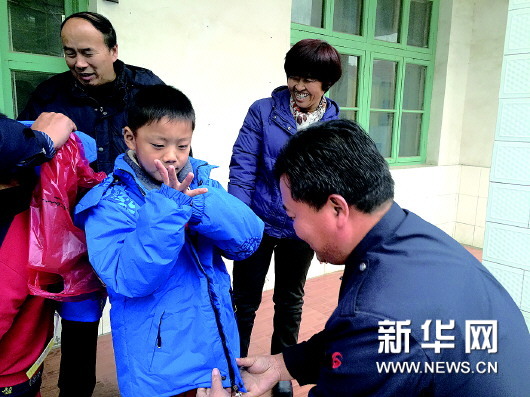 出租車駕駛員為學(xué)生試穿羽絨服