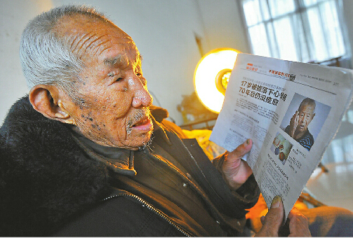 看到本报曾经报道过的跟自己一起被掳往日本的劳工张景全的照片，师朝明老人回忆起当年的情景。 记者郭尧 摄