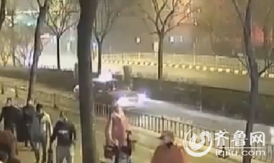 近二十名男子浩浩荡荡地自东向西进入监控视野,他们都戴着口罩遮住脸,拎着大锤。(视频截图)