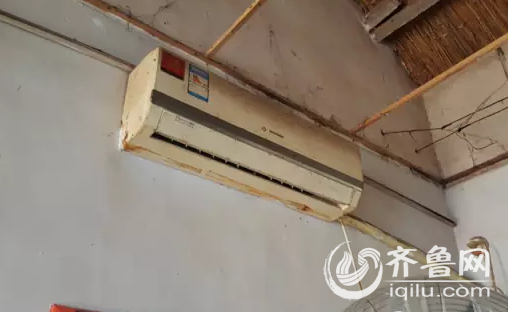 墻上掛著個空調(diào)，冷不能吹，熱不能開，記者仔細查找，但沒有發(fā)現(xiàn)空調(diào)遙控器的影子，（齊魯頻道記者拍攝）