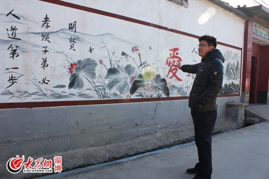 张海向记者介绍村里新刷的文化墙