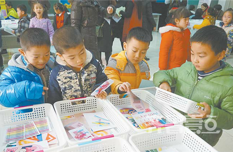(民生大街小學一年級的同學在“超市”選擇期末語文考試的題目卡片。)