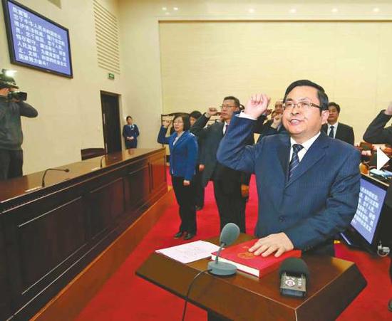 14日,12名新任命的公職人員向憲法宣誓。 濟南日報記者范良攝14日,12名新任命的國家機關工作人員面向國徽,向憲法宣誓。