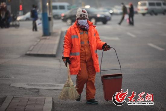 1月20日上午,在济南市历下区历山路上,环卫工人张大姐正在埋头清扫马路。张大姐告诉大众网记者,她和老公从事环卫工作已经10年了,近几年感觉待遇比以前好了很多,她和企事业单位职工一样,享受老有所养、病有所医的实惠。大众网记者 王长坤 摄