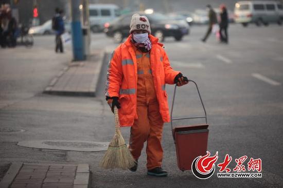 1月20日上午，在济南市历下区历山路上，环卫工人张大姐正在埋头清扫马路。张大姐告诉大众网记者，她和老公从事环卫工作已经10年了，近几年感觉待遇比以前好了很多，她和企事业单位职工一样，享受老有所养、病有所医的实惠。大众网记者 王长坤 摄