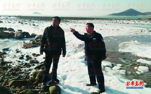 纪甲地和民警来到 事 发现场,已经退潮,附近海滩上大面积结冰。 (警方供图)
