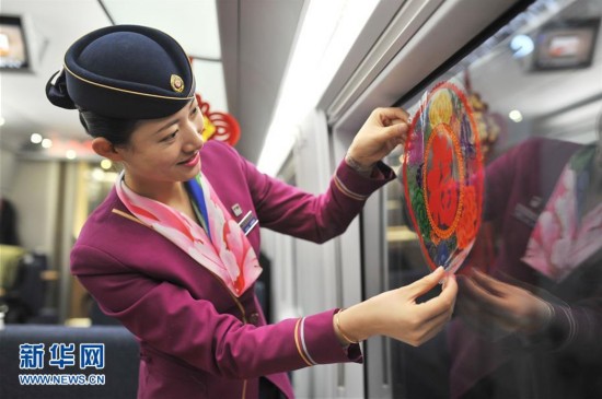 1月30日，在由青岛发往北京的G184列车上，乘务人员给列车贴上窗花。春节临近，人们开始加紧准备年货，各地张灯结彩，到处洋溢着节日的气息。 新华社发