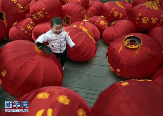 1月30日，在貴州省貴陽市一街道邊，一名小朋友在大紅燈籠堆中玩耍。春節臨近，人們開始加緊準備年貨，各地張燈結彩，到處洋溢著節日的氣息。 新華社發（彭年）