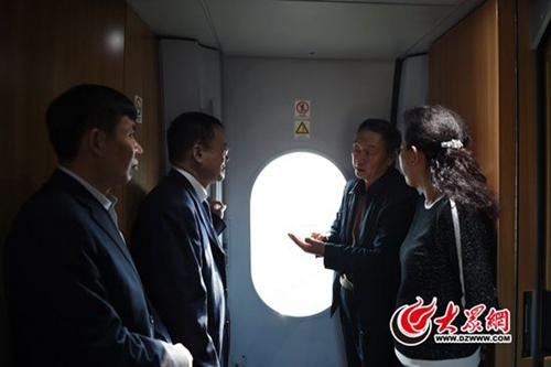 　3月2日下午，出席第十二届全国人大第四次会议的住鲁全国人大代表在赴京列车上认真讨论准备向大会提交的建议。大众网记者 王长坤 摄