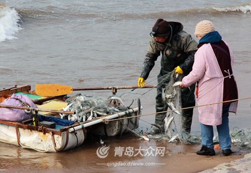 市民撒網在近海岸捕魚