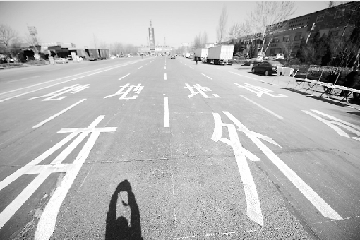 10日,靠近济南黄河大桥收费站的路段,交警部门重新喷绘了道路标志。 记者王锋 摄