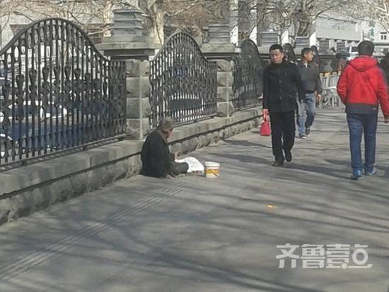 齊魯醫院門口一位乞討大爺席地而坐