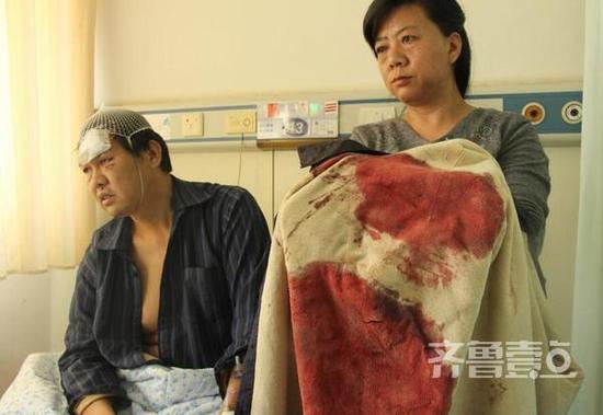 李立民(左)受傷時穿的襯衣上染滿了鮮血,上面的刀口清晰可見。(齊魯壹點記者 杜雅楠 攝)
