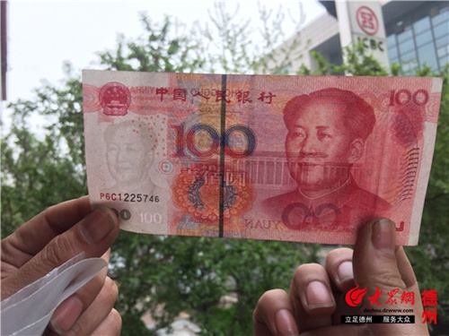 王先生向記者展示他收到的百元“錯(cuò)幣”