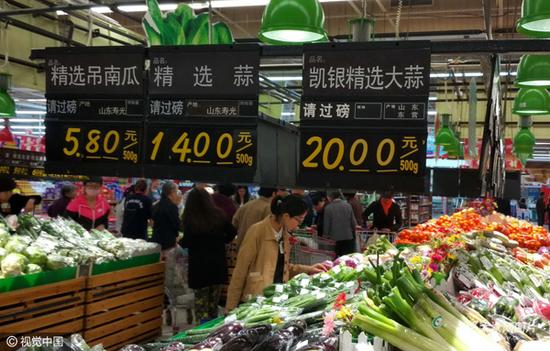 济南一家大型超市里，两家卖蒜的柜台，一个是20元一斤，一个是15元一斤。就是便宜的蒜，4头也需六块多。图片作者:视觉中国