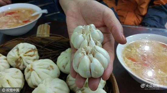 大蒜涨价太狠，餐饮店里顾客吃包子或者饺子不再有免费的大蒜，一元钱一头。图片作者:视觉中国