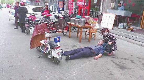 過路女子正在救助老人 記者丁國彬 攝