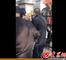 被拉起来的老人被几名男子推搡到围墙栏杆上。