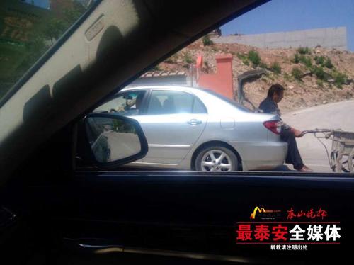 大叔坐后備箱，手里拉著小推車。