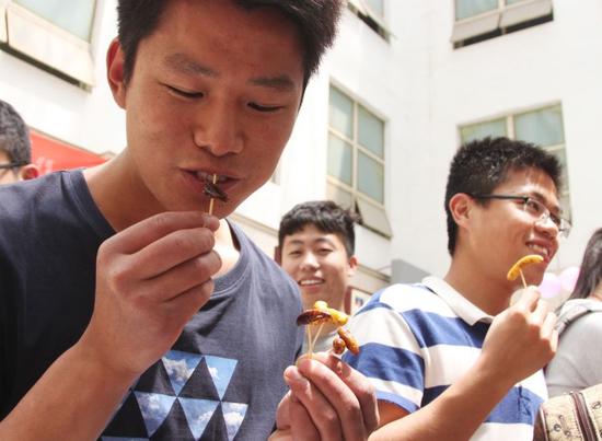 学生在品尝各式昆虫宴的菜品。记者 尹倩倩 摄