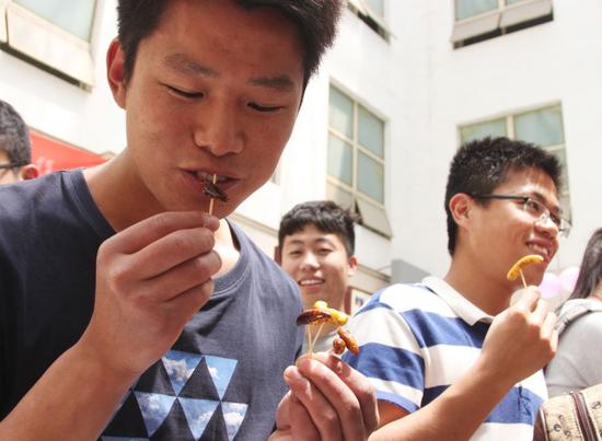 學生在品嘗各式昆蟲宴的菜品。記者 尹倩倩 攝