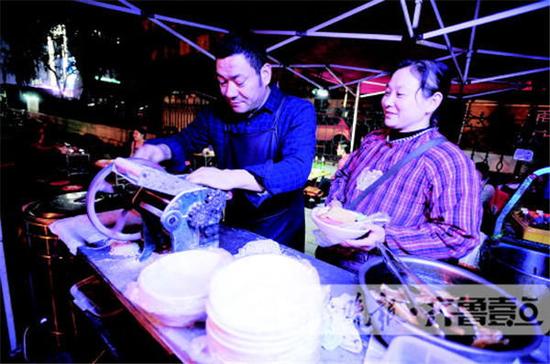 泺源大街与历山路交会口,李源和妻子在忙着为客人做板面。齐鲁晚报·齐鲁壹点 记者周青先摄