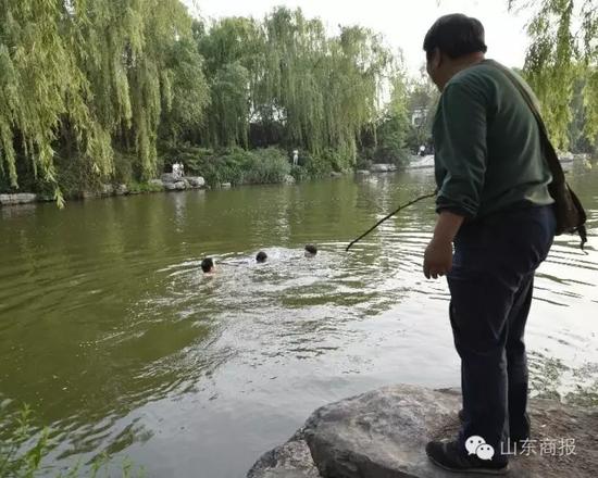 一位熱心的市民正拿著一根木棍打算接應下水救人的好心人 市民 單東衛 攝
