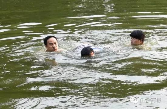 两名好心人开始水中营救那名溺水男子 市民 单东卫 摄