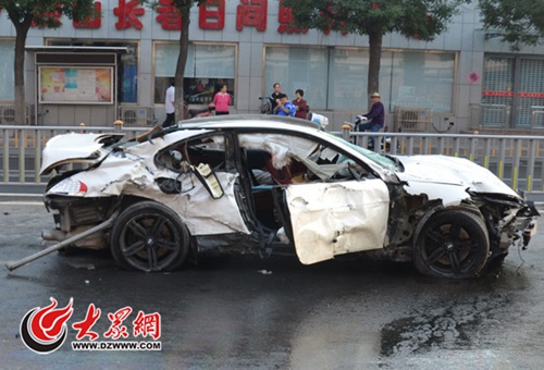 肇事寶馬轎車前后保險杠都已撞掉,車門玻璃全部粉碎,輪胎全部爆胎
