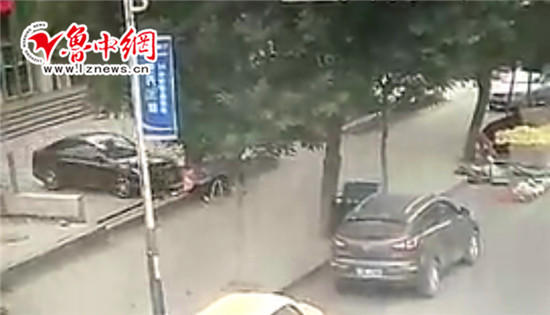 附近視頻監控顯示，畫面左側，一輛黑色轎車正在停車，而車前坐著兩名環衛工人。