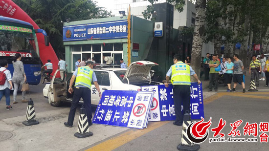 煙臺公安部門的高考服務(wù)車到達考點,民警正在設(shè)置警示牌