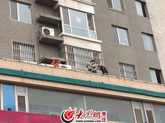 消防官兵在4樓平臺(tái)救援墜落小孩和老人
