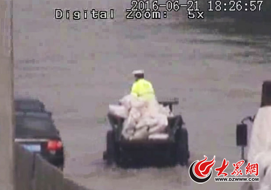 業(yè)南路煉油廠路口,交警劉金亮征用拖拉機救出被困水中的市民