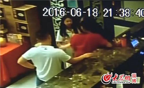 中年婦女與男子在前臺繼續對小張進行毆打