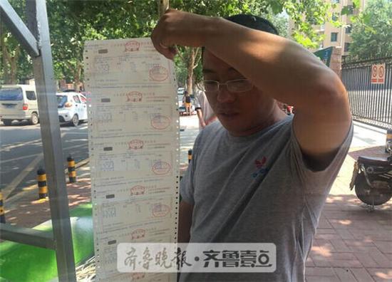 為證明自己在濟南居住,付先生打印了水電等各種收據。齊魯晚報·齊魯壹點 記者時培磊攝