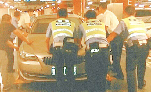 (七八個人合力在恒隆廣場推這輛寶馬車。交警供圖)