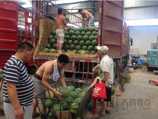 在堤口路果品批发市场，批发商正在卖瓜。