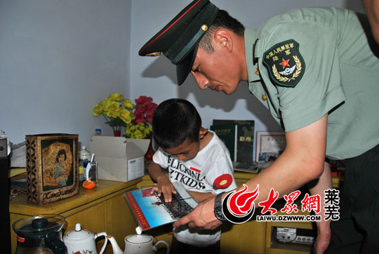 楊樹朋生前戰友為楊一鳴翻看部隊合影