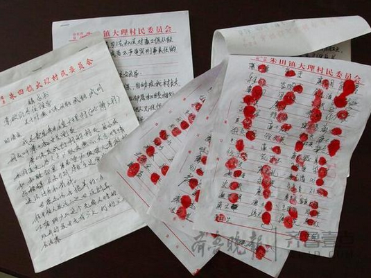 按滿百名村民紅手印的求情書。