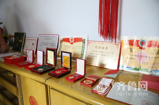 一側的桌子上,擺滿了楊樹朋生前所獲的榮譽證書和軍功章。