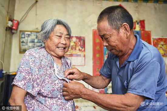 付守桂幫助視力不好的妻子遲明秀系扣子，準(zhǔn)備外出。