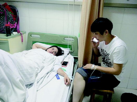 因呕吐腹泻入院的游客正虚弱地躺在病床上。本报记者 徐艳 摄