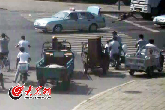 吳某從兩輛出租車之間穿過時,一個趔趄騰空倒地
