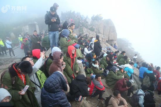 国庆节首日,十一小长假首日数万游客登顶泰山,因山顶气温较低,不少游客为一睹泰山日出胜景,没有在旅馆入住的游客,只好穿着军大衣露宿山顶,或在路边席地而睡等待凌晨日出,场面壮观。