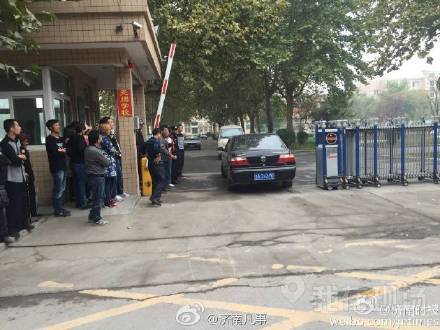 校门口围着大批居民,多辆警车进入学校处理此事。现场图片